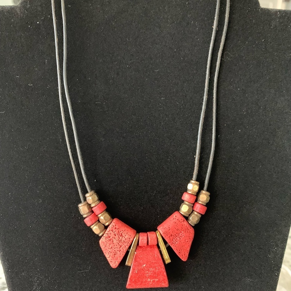 Vintage coral and gold colored beaded necklace on a leather chain.